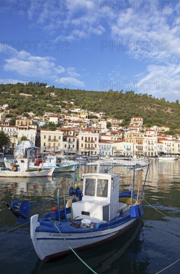 Small fishing boats in the Mediterranean harbour of Gythio or Gythion, behind houses and the