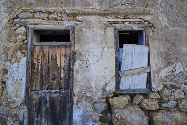 Old, weathered house façade with wooden door and shutters in rustic style, Mesochori village, west