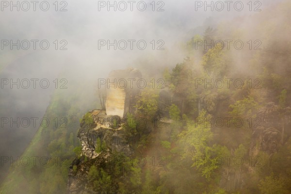 The bright Wartturm above the Elbe river, hidden in dense fog. Seen from the Bastei rocks near the