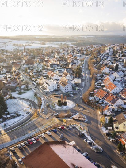 Town with snow-covered roofs and a central roundabout in winter light, Calw- Stammheim, Black