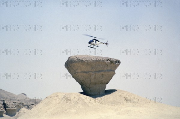 Bell 206 JetRanger helicopter landing on a rocky outcrop Arabian Desert, Saudi Arabia Oil industry