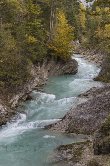 Rissbach creek flowing fast through the Riss valley. Autumn colors around