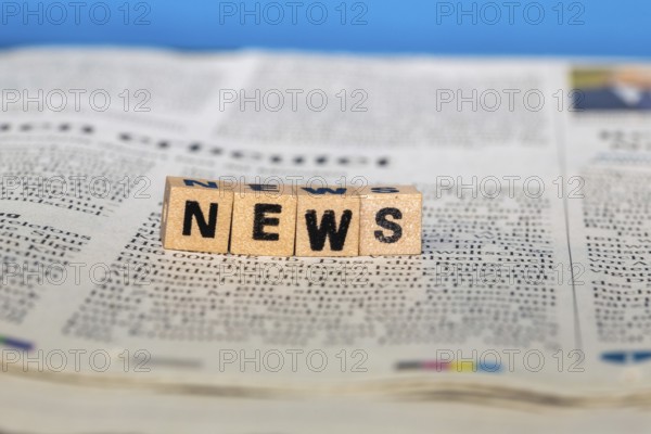 Symbolic image NEWS: Letter cube on a newspaper