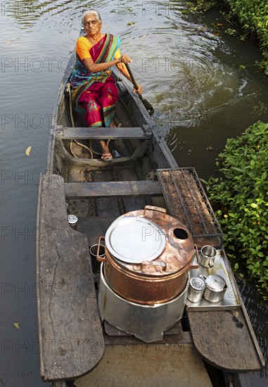 Tealady, 83 years old, paddling in her boat through the backwaters, Kumarakom, Kerala, India, Asia