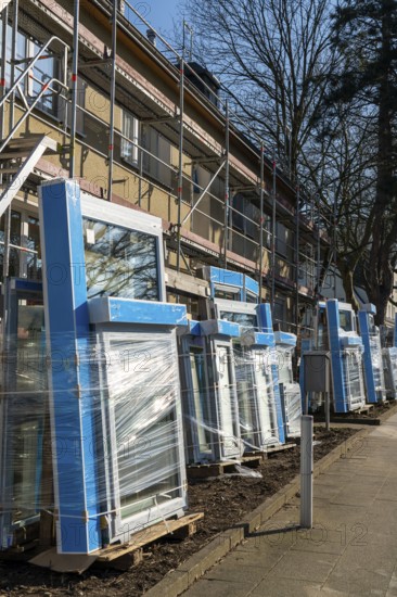 Energy-efficient refurbishment of residential buildings, older apartment block is scaffolded, gets