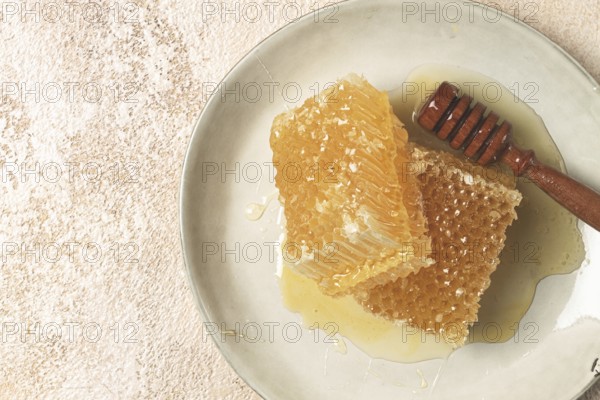 Honeycomb, with a wooden spoon-spindle, on a plate, no people