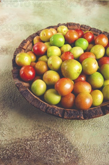 Cherry plum tkemali, fruit, plum variety, in a wooden plate, Georgian cuisine, top view, no people