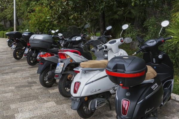 Black and white scooters including models Versilia 125 and Super B & W parked along the waterfront