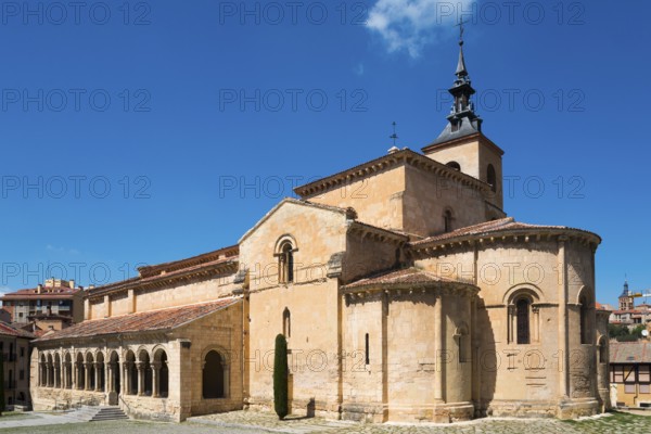 Historic church with stone arches and a Gothic tower under a blue sky, Church of San Millan,