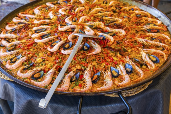 Giant pan and ladle with the Spanish national dish paella, hippie market Es Canar, Ibiza, Balearic