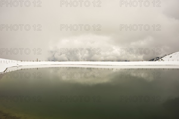 Onset of winter in May, Riezler Alpsee, an artificial lake, snow pond, feeds the snow cannons that