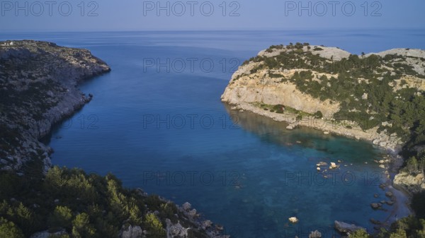 Drone shot, A picturesque, calm bay with crystal clear water and steep cliffs, surrounded by