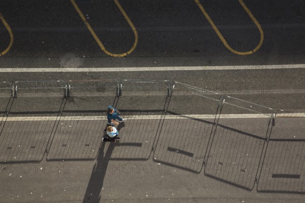 Top view of two middle aged women walking along a asphalt road surface in the port of La Spezia,