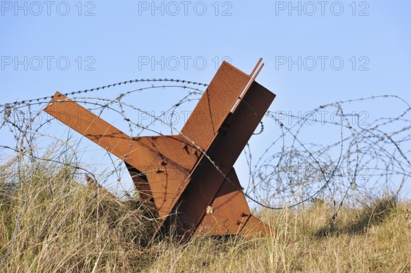 Barbed wire and Czech hedgehog static anti-tank defences from the Second World War on a beach in