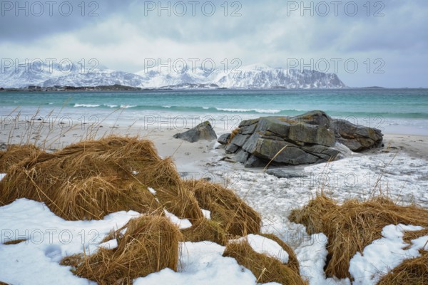 Waves of Norwegian sea on rocky beach of fjord. Ramberg beach, Lofoten islands, Norway, Europe