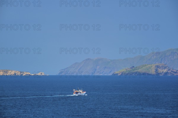 Greek fishing boat in blue waters of Aegean sea near Milos island, Greece, Europe