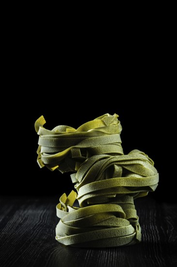 Low key photo of italian tagliatelle with spinach