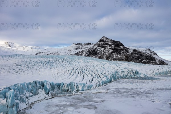 Snow-covered icebergs in the Fjallsarlon glacier lagoon, with the Öraefajökull glacier behind,