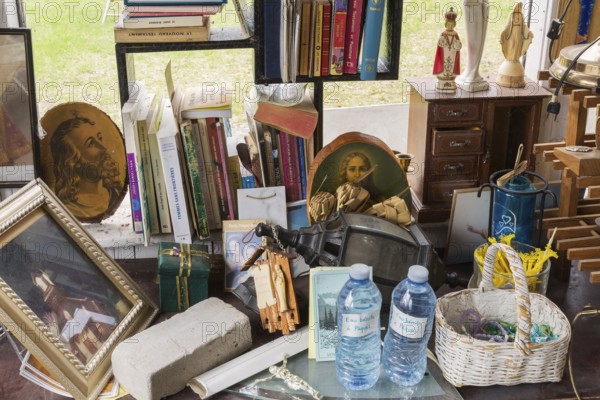 Religious statues, books and paintings for sale inside second hand goods and chattels store,