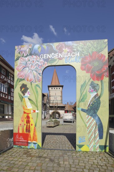 View to the historic Obertorturm through the main street with a poster and inscription to