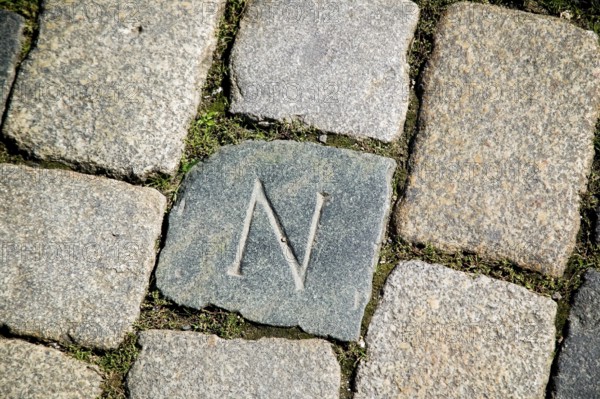 In front of the main entrance to the Hofkirche, a cobblestone is marked with an N. The cobblestone