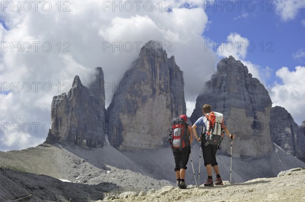 Couple mountain walkers admiring the Tre Cime di Lavaredo, Drei Zinnen, Dolomites, Italy, Europe
