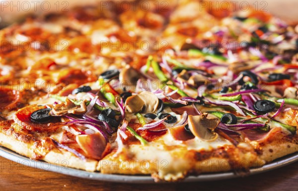 Close up of supreme pizza with olives on wooden table. Delicious Supreme Pizza and pepperoni on
