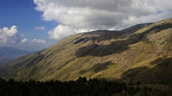 Hills, mottled green and yellow, light and shade, grey-white clouds, Madonie National Park, autumn,