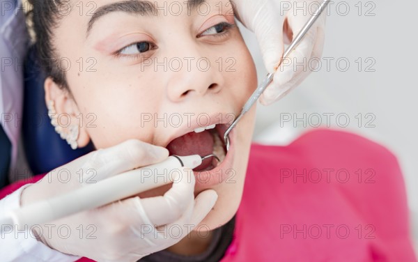 Close up of dentist checking patient with excavator and dental mirror, Dentist checking patient