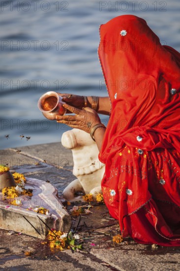 MAHESHWAR, INDIA, APRIL 26: Indian woman performs morning pooja on sacred river Narmada ghats on