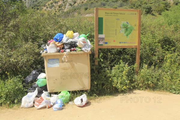 Overflowing rubbish bin at natural park, Cueva del Gato, Benaojan, Serrania de Ronda, Malaga
