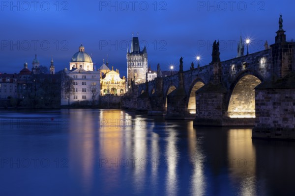 Charles Bridge with the Old Town Bridge Tower and the Church of the Holy Cross at the blue hour,