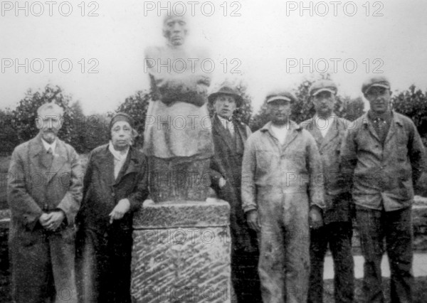 German artist Käthe Kollwitz posing with husband in front of sculpture group The Grieving Parents,