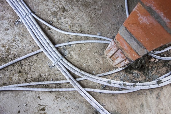 Electric wires, electrical cables, wiring fixed on the floor in newly built house under