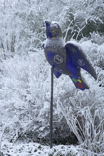 Blue Ulm sparrow with hoarfrost, ice and snow in winter, iced, sculpture, landmark, bird figure,