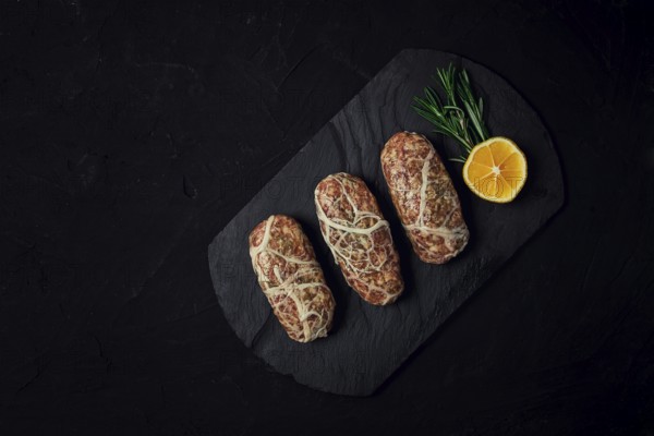 Traditional Cypriot Seftalia dish, raw, top view, on a black background, no people
