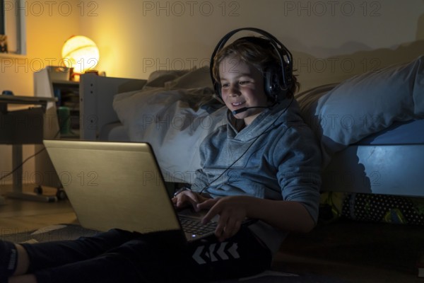 Boy, at home on the computer, laptop, in the children's room, playing a game, chatting with other