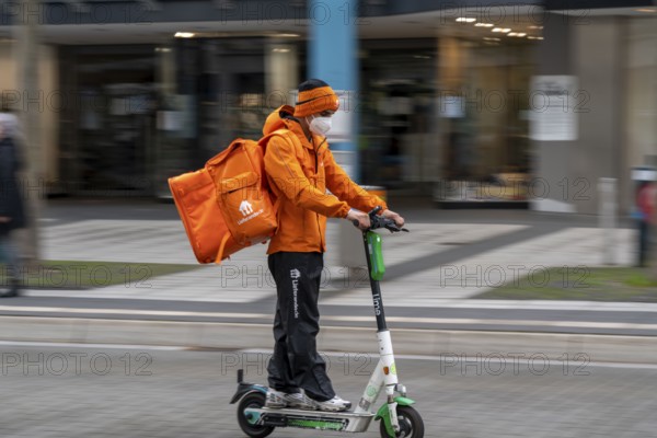 Delivery service Lieferando.de, delivery courier with e-scooter in the city centre, Rathenaustraße,