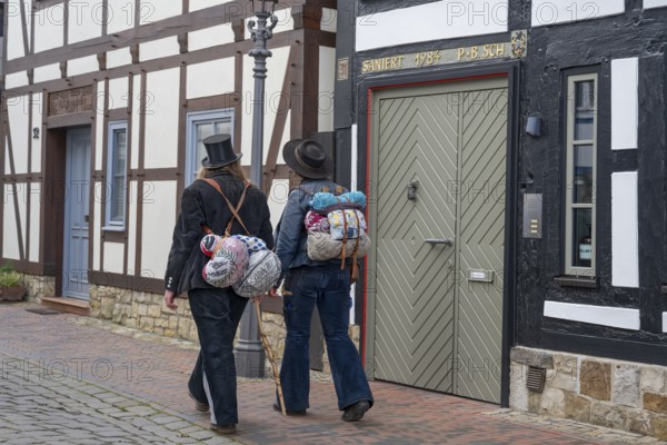 Travelling craftsmen on the road through half-timbered alley Rinteln Germany