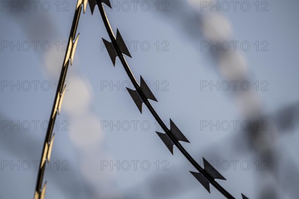 Symbolic image security, S-wire rolls, NATO wire, on a fence top, demarcation of a property,