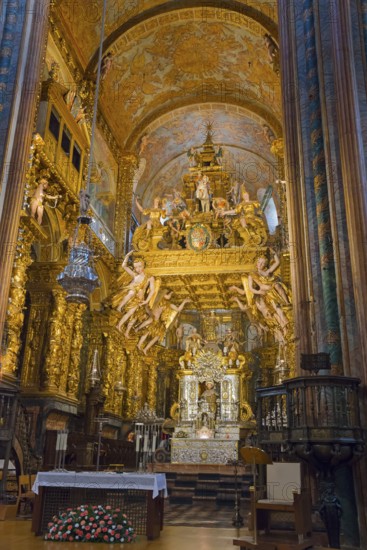 Gold-decorated Baroque church interior with an ornately decorated altar and angels, cathedral,