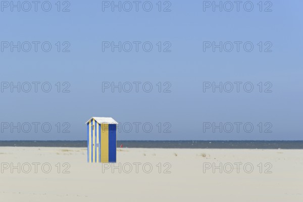 Blue and yellow cottage, beach shower on the extensive sandy beach, blue sky, North Sea, Juist,
