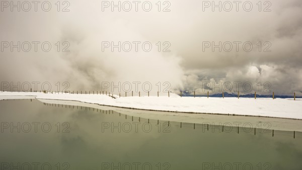 Onset of winter in May, Riezler Alpsee, an artificial lake, snow pond, feeds the snow cannons that