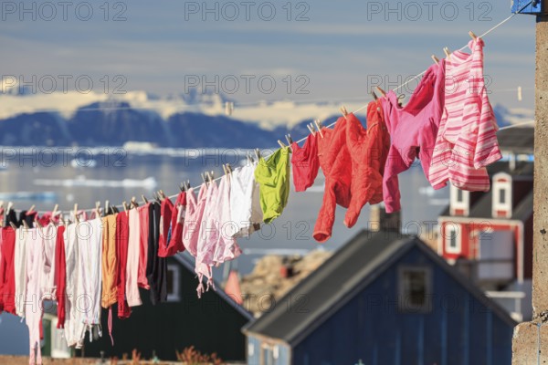 Colourful laundry drying on a washing line in an Inuit settlement, Ittoqqortoormiit, Scoresby Sund,
