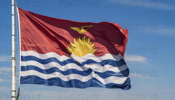The flag of Kiribati, Polynesia, flutters in the wind, isolated against a blue sky