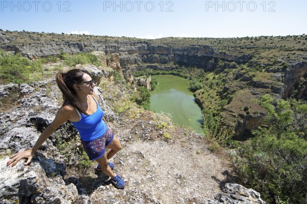 Castilian woman, 48 years old, looking at the gorge and the river Duratón, canoes on the water, on