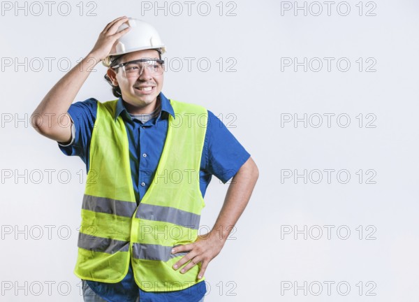Troubled young engineer holding head isolated. Worried builder engineer holding head isolated.