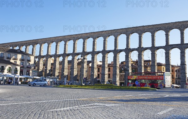 Sightseeing bus at the Roman aqueduct in Plaza de Azoguejo, Segovia, province of Segovia, Castile