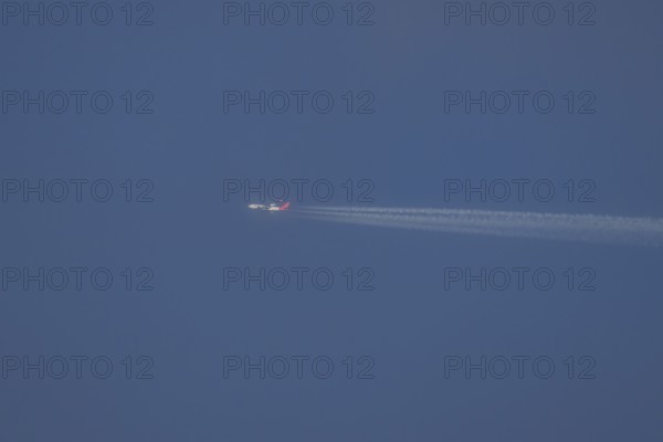 Boeing 747 jumbo jet aircraft in flight with a contrail or vapour trail in the sky, England, United