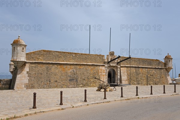 Old stone fortress by the road under a blue sky, Forte da Ponta da Bandeira, Fortress, Lagos,